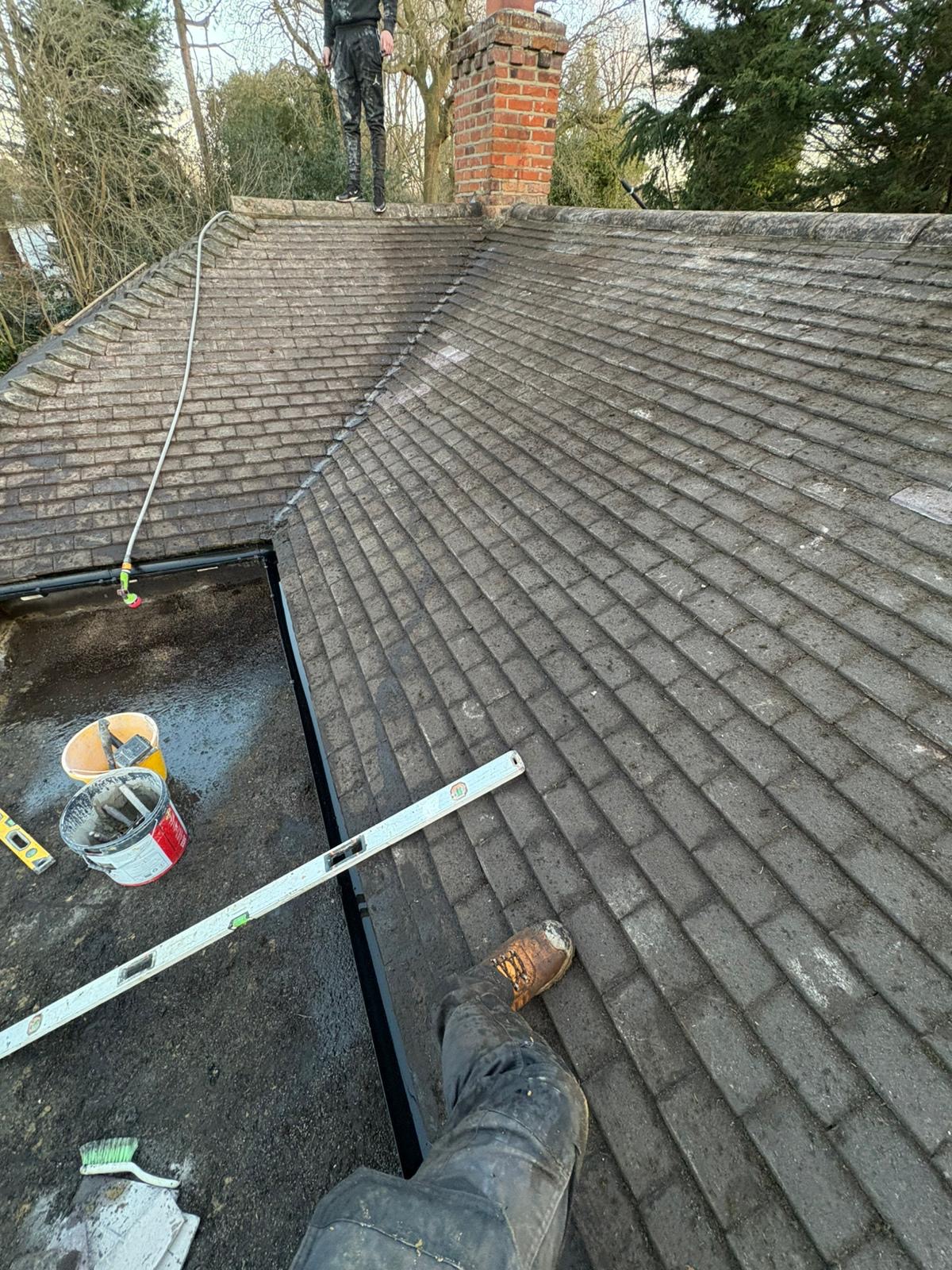 Roof tiles after the moss was cleared, with tools on the roof
